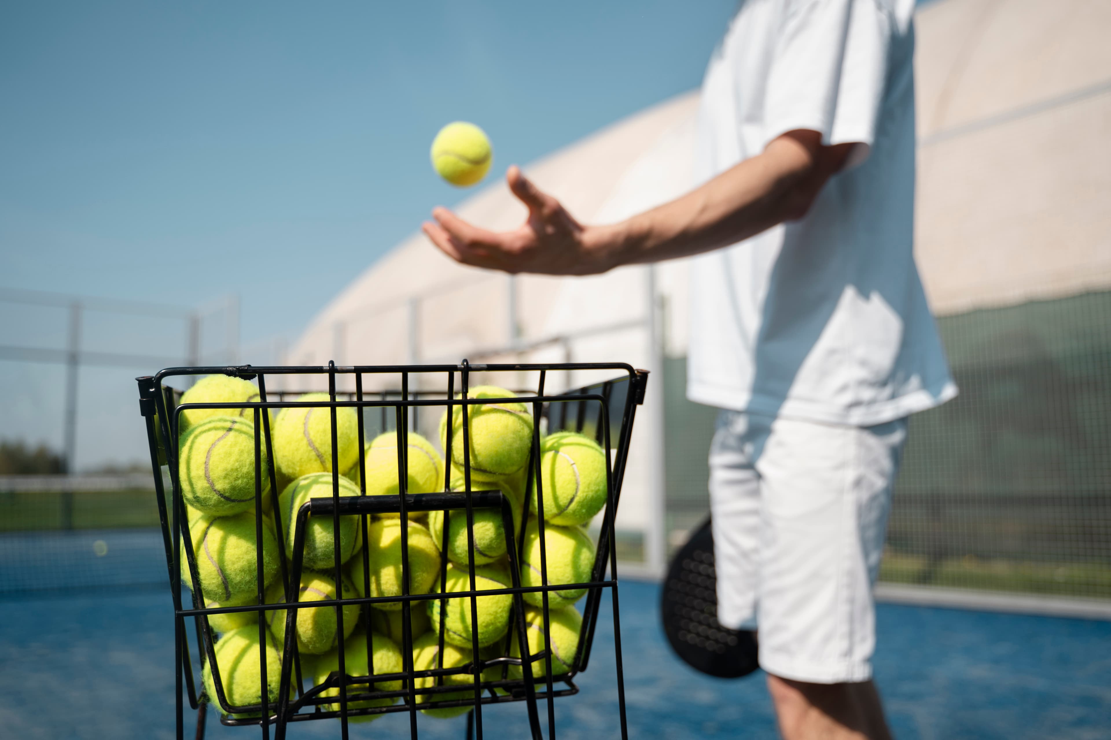 Kortta tenis topları ve antrenman sepeti